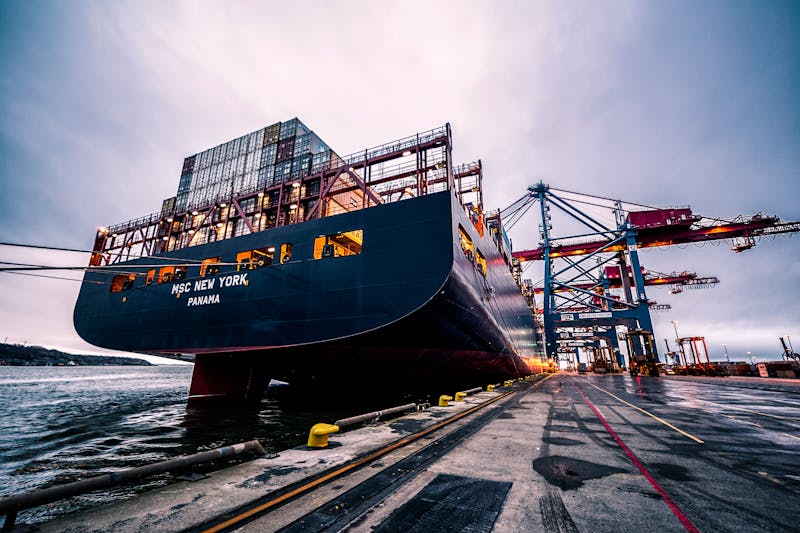 Stacked shipping containers at a busy port terminal