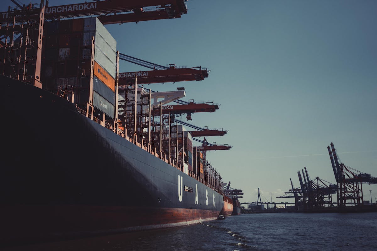 RORO vessel with open stern ramp loading vehicles at port